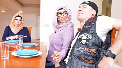 Hijab-wearing doll providing a hand job from under the table