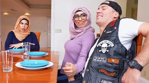 Hijab-wearing lady giving a forearm-job from under the table